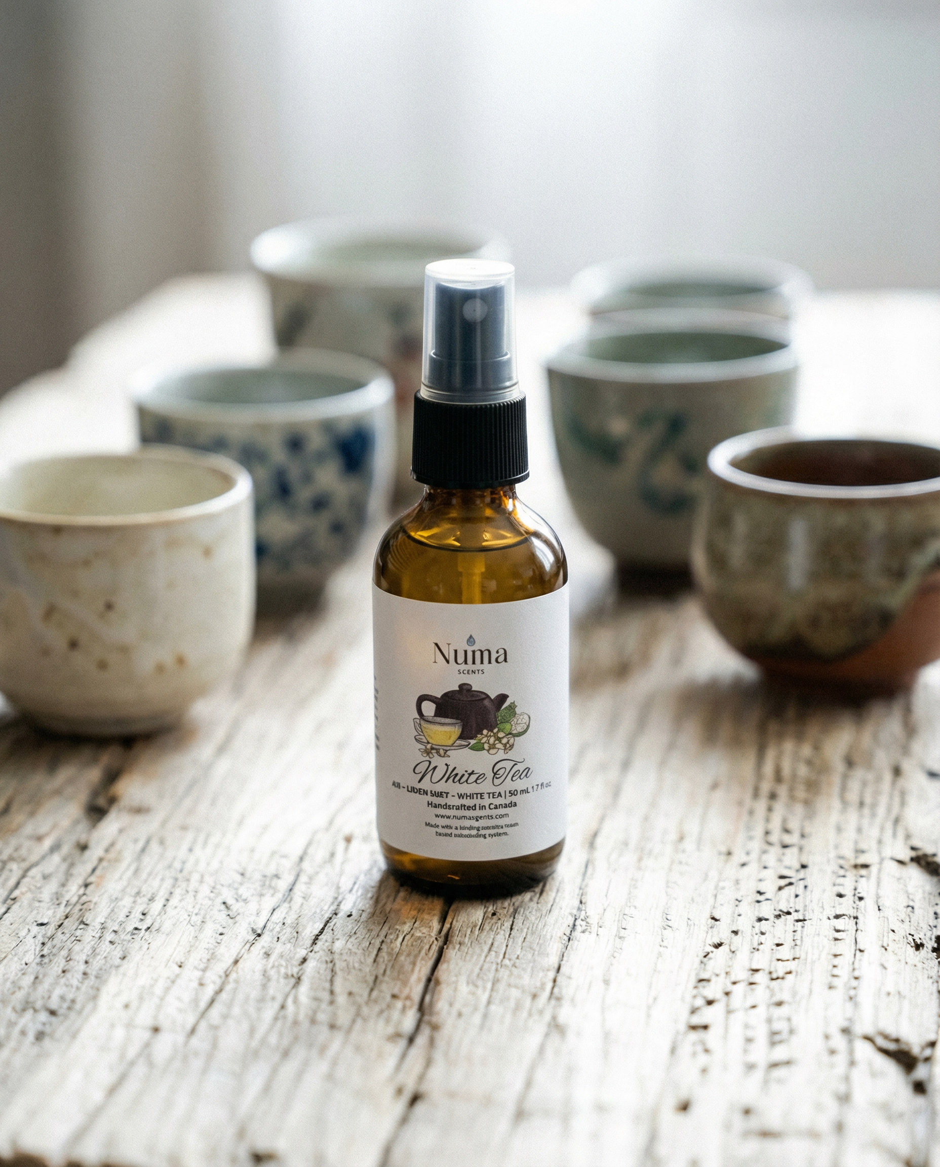 Bottle of room spray linen spray product on a wooden surface with ceramic bowls in the background