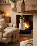 Car diffuser air freshener from Numascents hanging in a cozy living room with a fireplace.